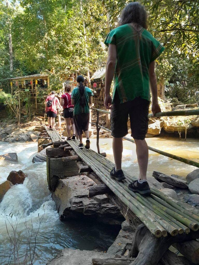 A group of people walking on a bridge over a river, captured in an image gallery.