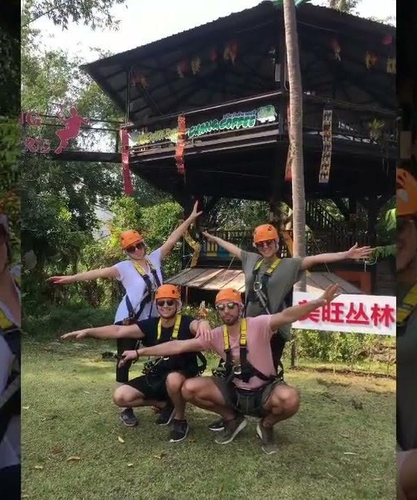 A group of people wearing safety gear while ziplining in Chiang Mai.