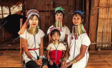 A group of Thai women and children donning Karen clothes pose for a photo.