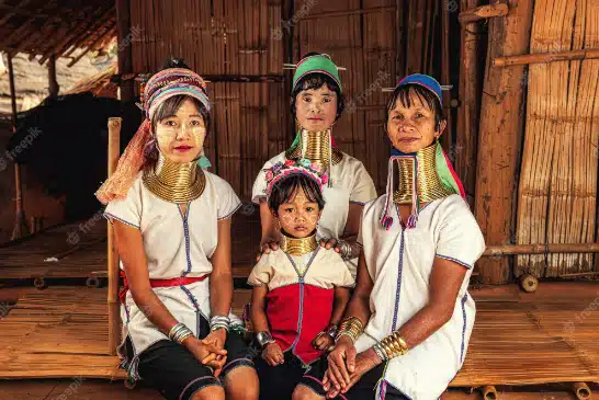 A group of Thai women and children donning Karen clothes pose for a photo.